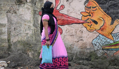 A woman walks past graffiti in Mumbai